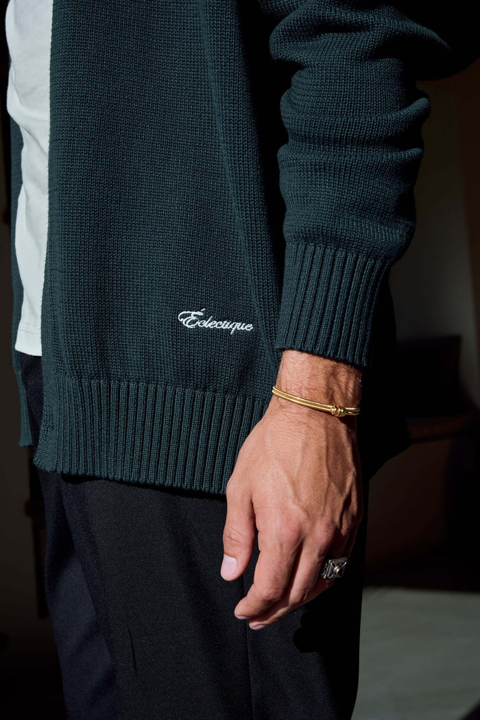Close-up of green v neck cardigan Scarab green knit and hem details