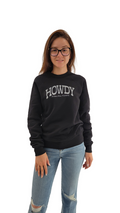 A person wearing a black sweatshirt with the text 'HOWDY' on it, standing against a white background.