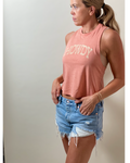 woman wearing tank top in Sunset color with Howdy text on it