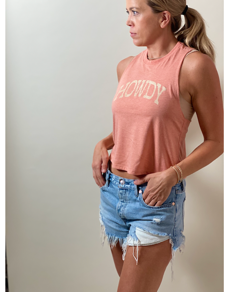woman wearing tank top in Sunset color with Howdy text on it