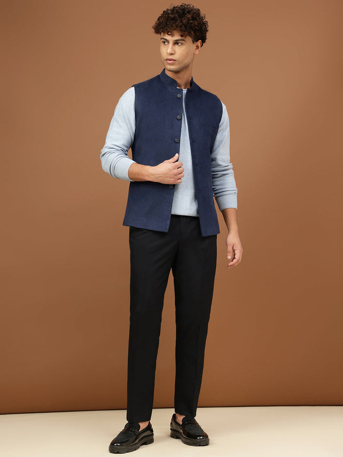 Man wearing a navy blue Nehru jacket with a mandarin collar over a light grey shirt