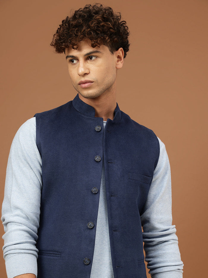 Man wearing a navy blue Nehru jacket with a mandarin collar over a light grey shirt