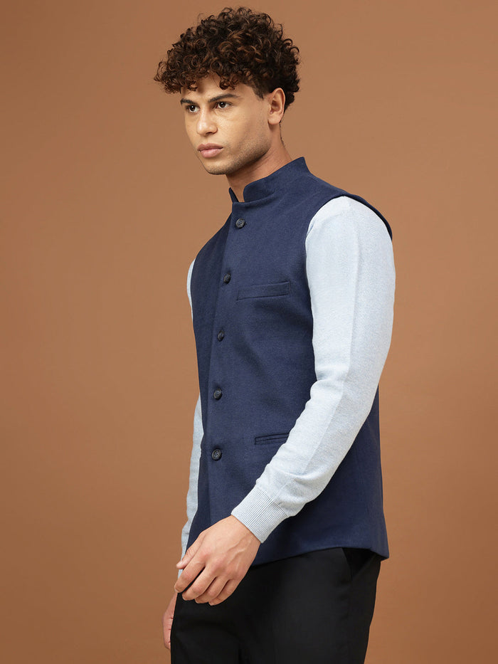 Man wearing a navy blue Nehru jacket with a mandarin collar over a light grey shirt