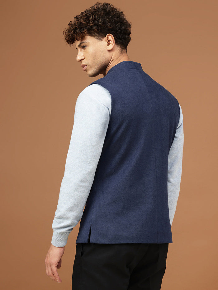 Man wearing a navy blue Nehru jacket with a mandarin collar over a light grey shirt