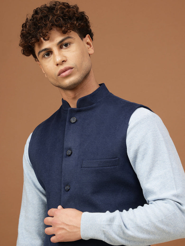 Man wearing a navy blue Nehru jacket with a mandarin collar over a light grey shirt