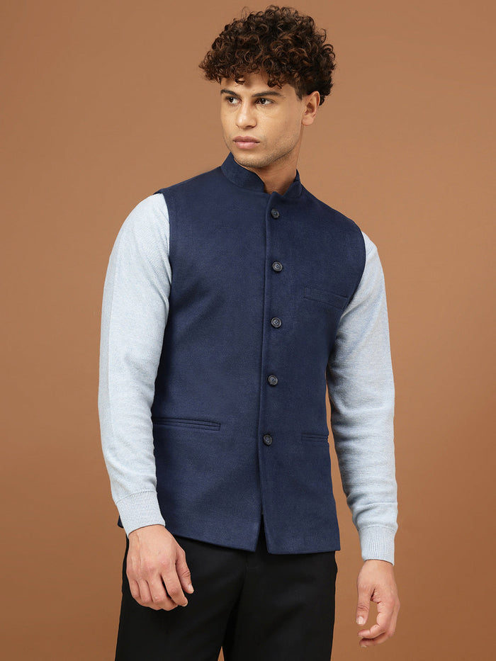 Man wearing a navy blue Nehru jacket with a mandarin collar over a light grey shirt