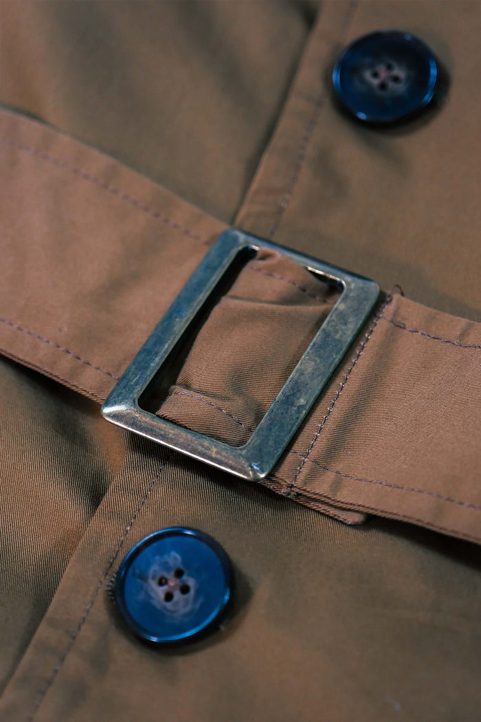 Detail of the belt buckle and buttons on the Men’s Camel Trench Coat – Manny showcasing classic design elements.