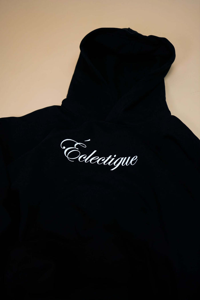 Midweight cotton hoodie with Éclectique script logo on black fabric, perfect for casual wear.