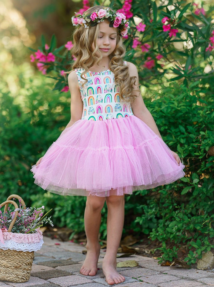 Girls dress has a white bodice with rainbow prints and a full pink tutu skirt