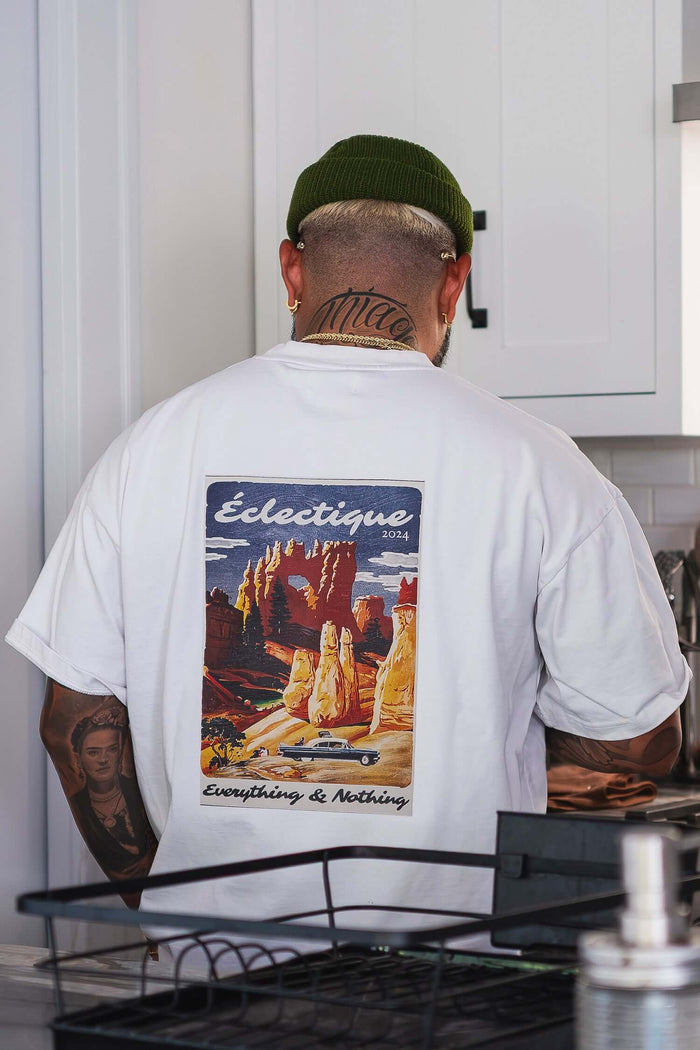 Man wearing a Sedona graphic T-shirt with a colorful desert landscape illustration on the back.