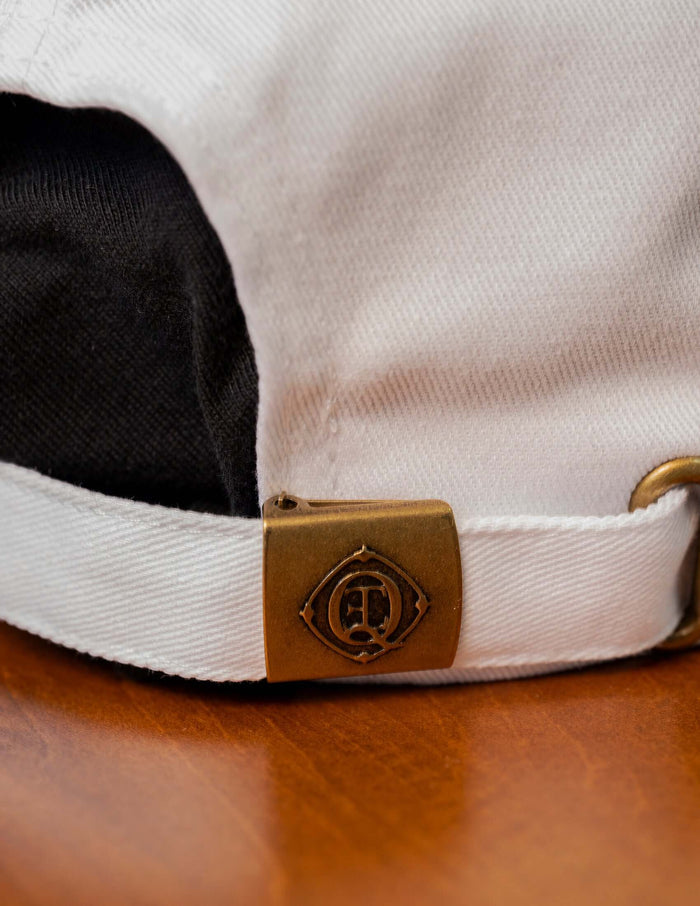 Close-up of the adjustable back strap of the Super Sonique baseball cap with antique brass details.